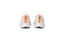 Une paire de baskets Crivit blanches avec des accents orange, vue de derrière.