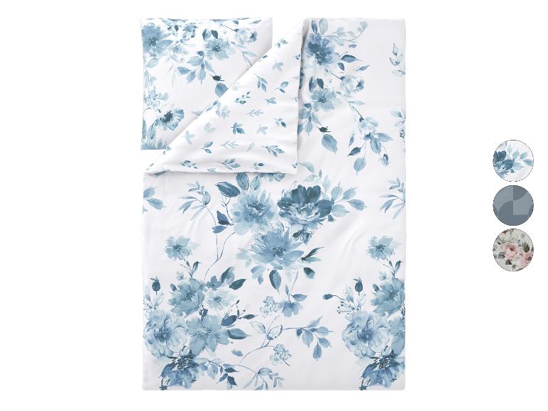 Parure de lit avec housse de couette et taie d'oreiller à motif floral bleu aquarelle sur fond blanc.