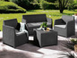 Un salon de jardin avec deux fauteuils, un canapé et une table basse dans un jardin.