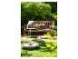 Banc de jardin en bois avec coussins, table d'appoint et fontaine dans un jardin.