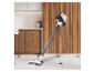Aspirateur sans fil Invictus dans une cuisine moderne avec des panneaux en bois et des armoires blanches.