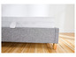Un sommier de lit gris avec un matelas blanc.