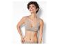 Une femme porte un soutien-gorge beige et des culottes assorties.