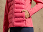 Une veste rose matelassée avec une fermeture éclair.