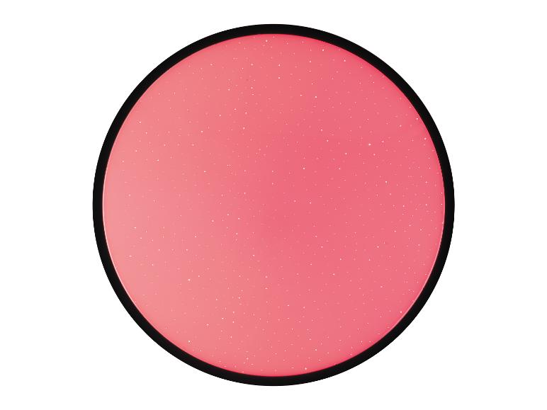 Une lampe ronde rose avec des points blancs.