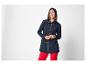 Femme souriante en parka bleu marine et pantalon rouge