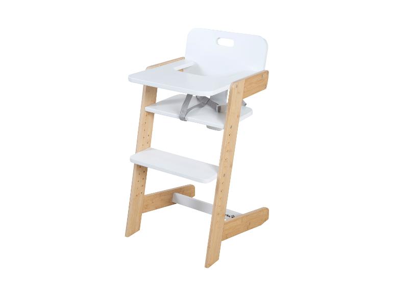 Chaise haute en bois avec assise et tablette blanches, dotée d'un harnais de sécurité gris.