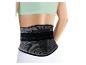 Femme portant une ceinture de soutien lombaire noire et grise sur un haut de sport vert clair.