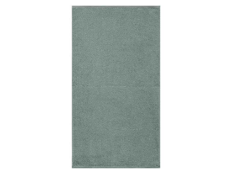 Une serviette de bain vert clair avec une texture en coton.