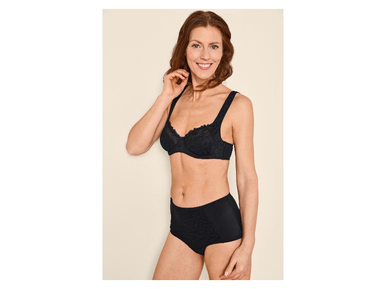 Femme souriante en soutien-gorge et culotte noirs à motifs floraux.
