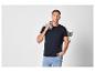 Homme en t-shirt noir et jean bleu clair, avec une veste en jean sur l'épaule.