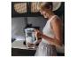 Une femme tenant une carafe filtrante en verre BRITA dans une cuisine.