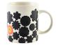 Une tasse blanche avec des fleurs noires et un smiley