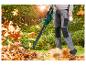 Une personne utilise un souffleur à feuilles sans fil Parkside pour nettoyer les feuilles d'automne.
