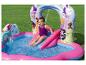 Fille glissant dans une piscine gonflable sur le thème des princesses.