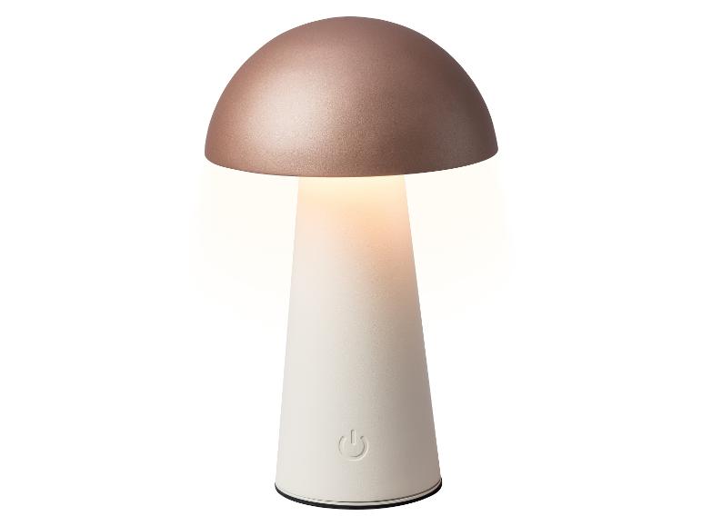 Lampe de table en forme de champignon avec un dessus or rose et une base blanche, émettant une lumière chaude.