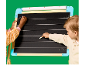 Deux enfants écrivant à la craie sur un tableau noir ligné pour apprendre à écrire.