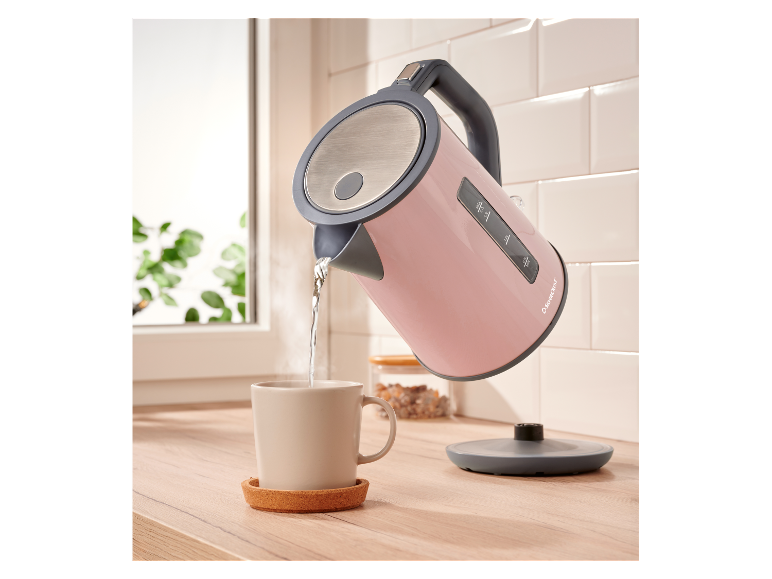 Une bouilloire rose SilverCrest verse de l'eau dans une tasse.