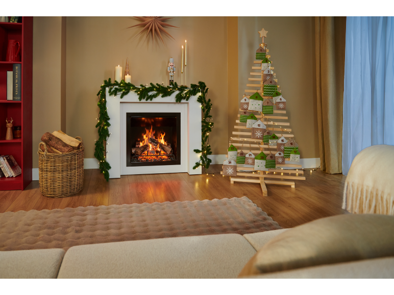 Calendrier de l'Avent en bois en forme de sapin de Noël dans un salon chaleureux avec cheminée.