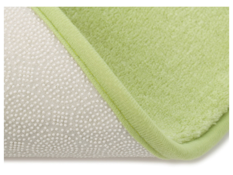 Un tapis de bain vert avec un dessous antidérapant.