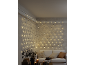 Guirlande lumineuse LED en filet sur un mur dans un salon confortable avec canapé et bougies.