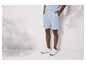 Un homme portant un short bleu et des baskets blanches.