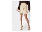 Jupe courte beige à volants et pull marron : look féminin et élégant.
