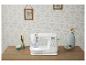 Machine à coudre blanche sur une table en bois avec des éléments décoratifs.
