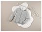 Sweat-shirt gris à capuche sur un fond de fourrure blanche