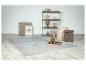 Tapis gris clair sur sol en marbre avec étagère, poufs et décorations.