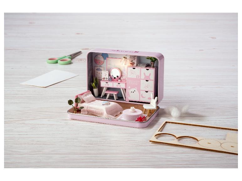 Une maison de poupée miniature rose Sweet Lullaby avec des meubles et des fournitures d'artisanat.
