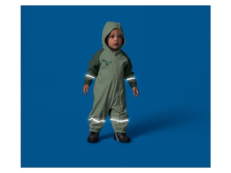 Enfant en bas âge dans une combinaison imperméable à capuche avec éléments réfléchissants, dinosaure.