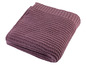 Une couverture en tricot rose foncé pliée sur un fond blanc.
