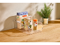 Organisateur transparent avec pâtes bio, lentilles et épices sur un comptoir en bois.