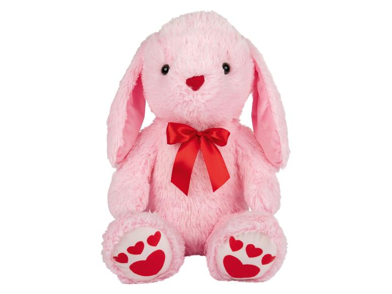 Lapin en peluche rose avec un nœud rouge.