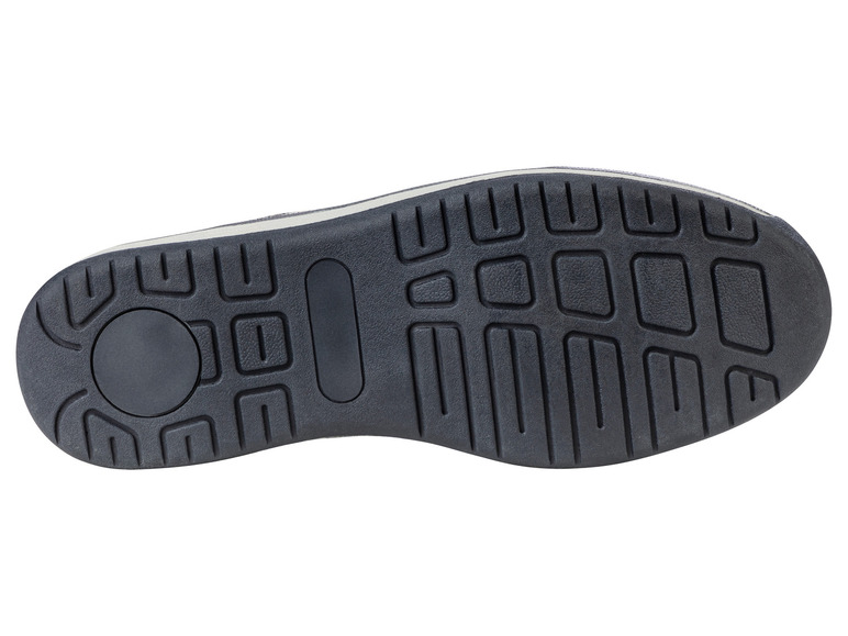 La semelle d'une basket noire avec une bande de roulement épaisse.