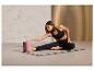 Une femme fait du yoga sur un tapis avec un bloc.