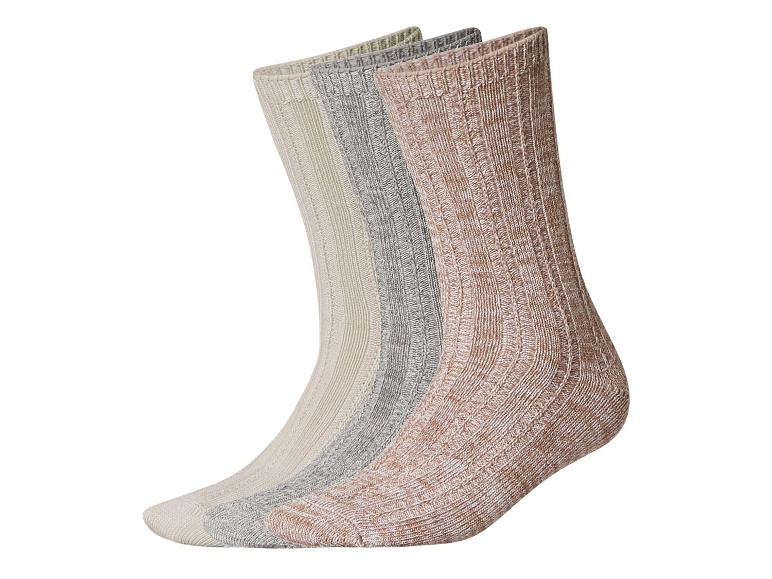 Trois chaussettes tricotées côtelées de couleurs neutres : beige, gris et marron rosé