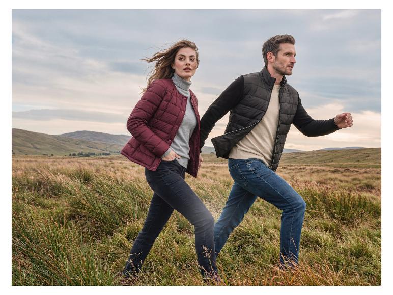 Homme et femme dans un paysage naturel, portant des doudounes et des jeans.