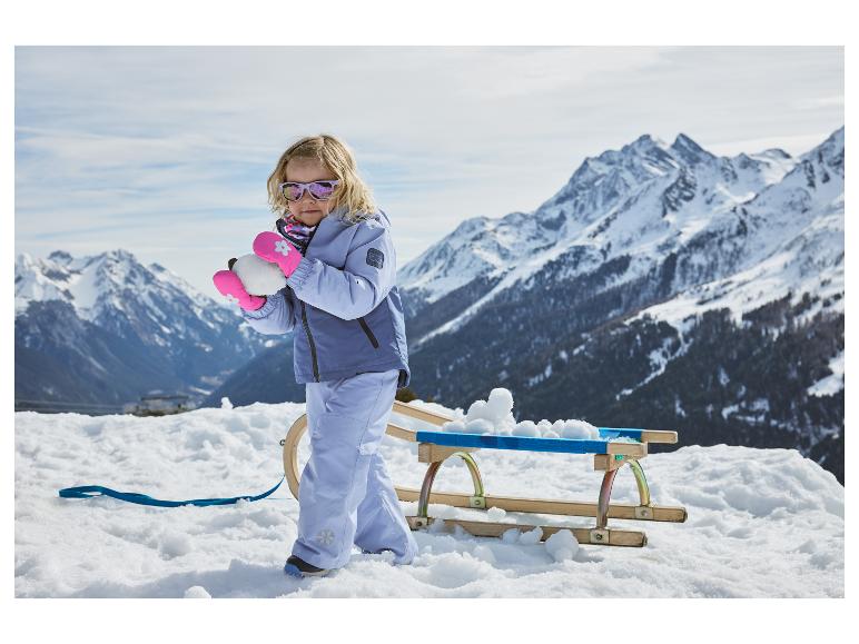 Fillette dans la neige portant des moufles pour enfants LUPILU® roses.