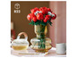 Un bouquet de fleurs LEGO avec des roses rouges dans un vase en verre.