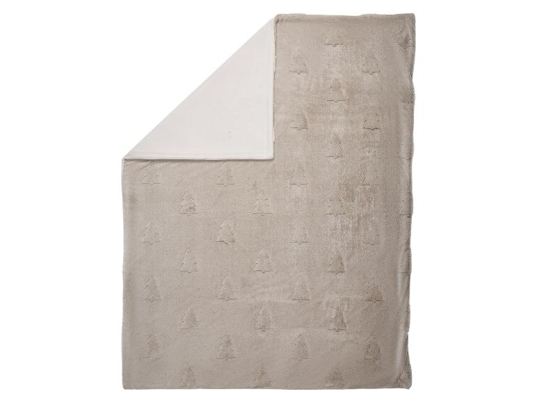 Couverture douce beige avec motif en relief de sapins de Noël, avec un côté blanc.