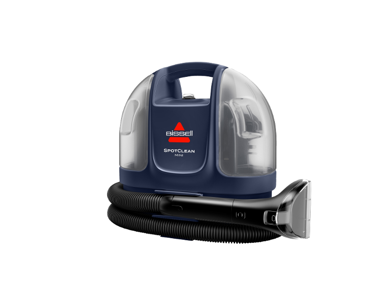 Nettoyeur de taches compact avec réservoir transparent et tuyau noir avec accessoire.