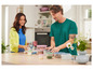 Un homme et une femme dans la cuisine avec plusieurs contenants de stockage, dont certains de Tupperware.