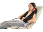 Femme se relaxant dans un fauteuil avec un masseur cervical et d'épaules