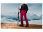 Des skis, des chaussures de ski et un pantalon de ski devant des montagnes.