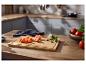 Planche à découper avec tomates, ail et basilic sur un comptoir de cuisine.