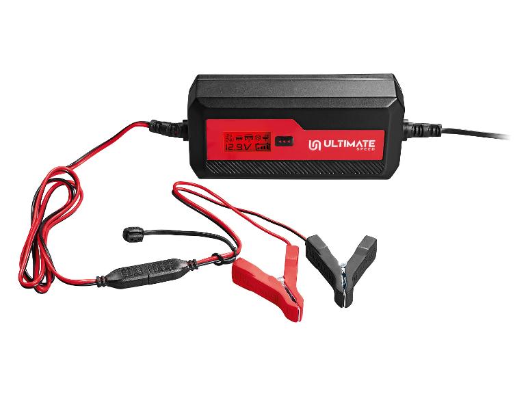 Un chargeur de batterie Ultimate Speed noir avec des pinces rouges.