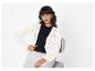 Modèle portant un cardigan crème ajouré et un pantalon beige.