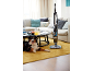 Aspirateur balai dans un salon avec un chien et une table basse.
